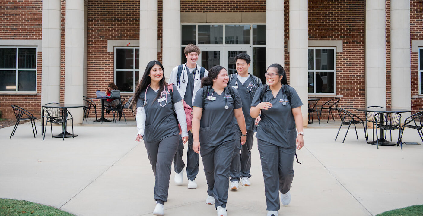 Mercer BSN students walking in front of Nursing building smiling