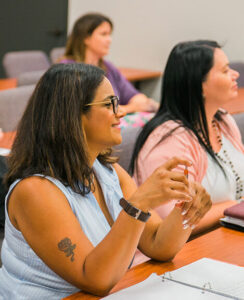 doctoral female counseling studenting holding pen in class and smiling