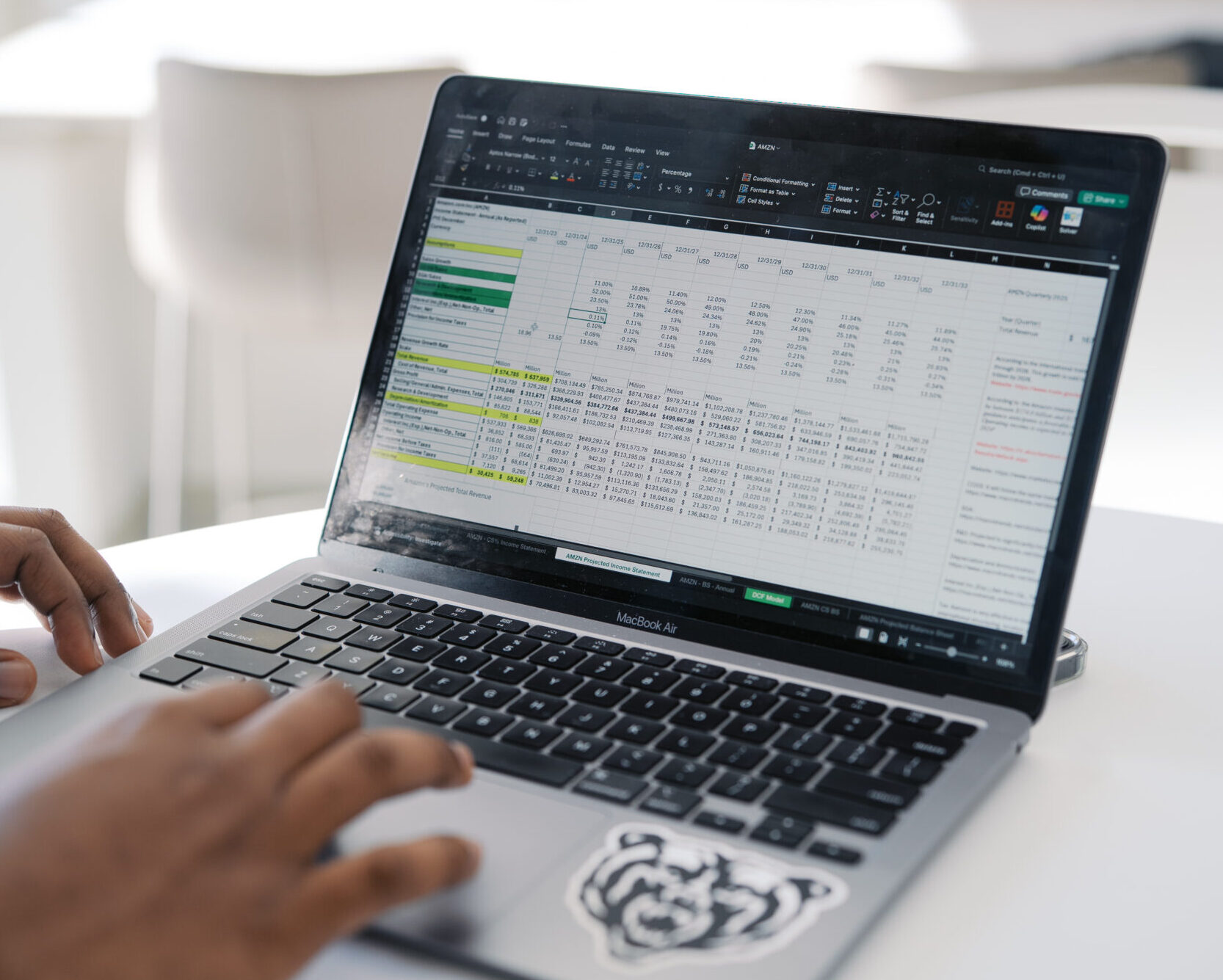 computer with data spreadsheet on screen; Mercer bear sticker on lower right of keyboard